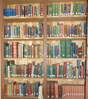 wooden library shelves filled with old hardcover books