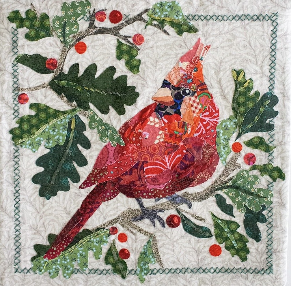 Quilt-style red cardinal perched among green oak leaves and red berries