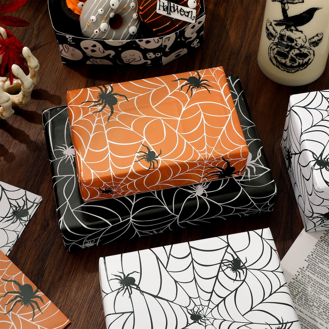 Halloween gift boxes wrapped in orange and black spider web paper with spooky decorations