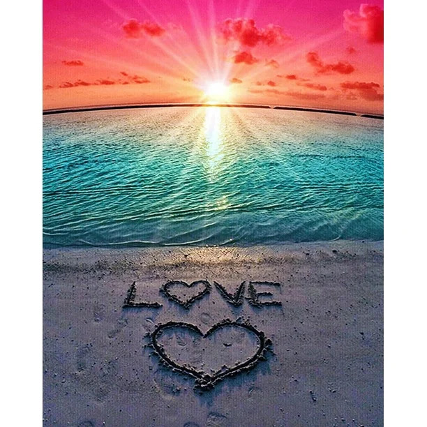Sunset beach scene with LOVE and heart drawn in sand, turquoise water and pink sky