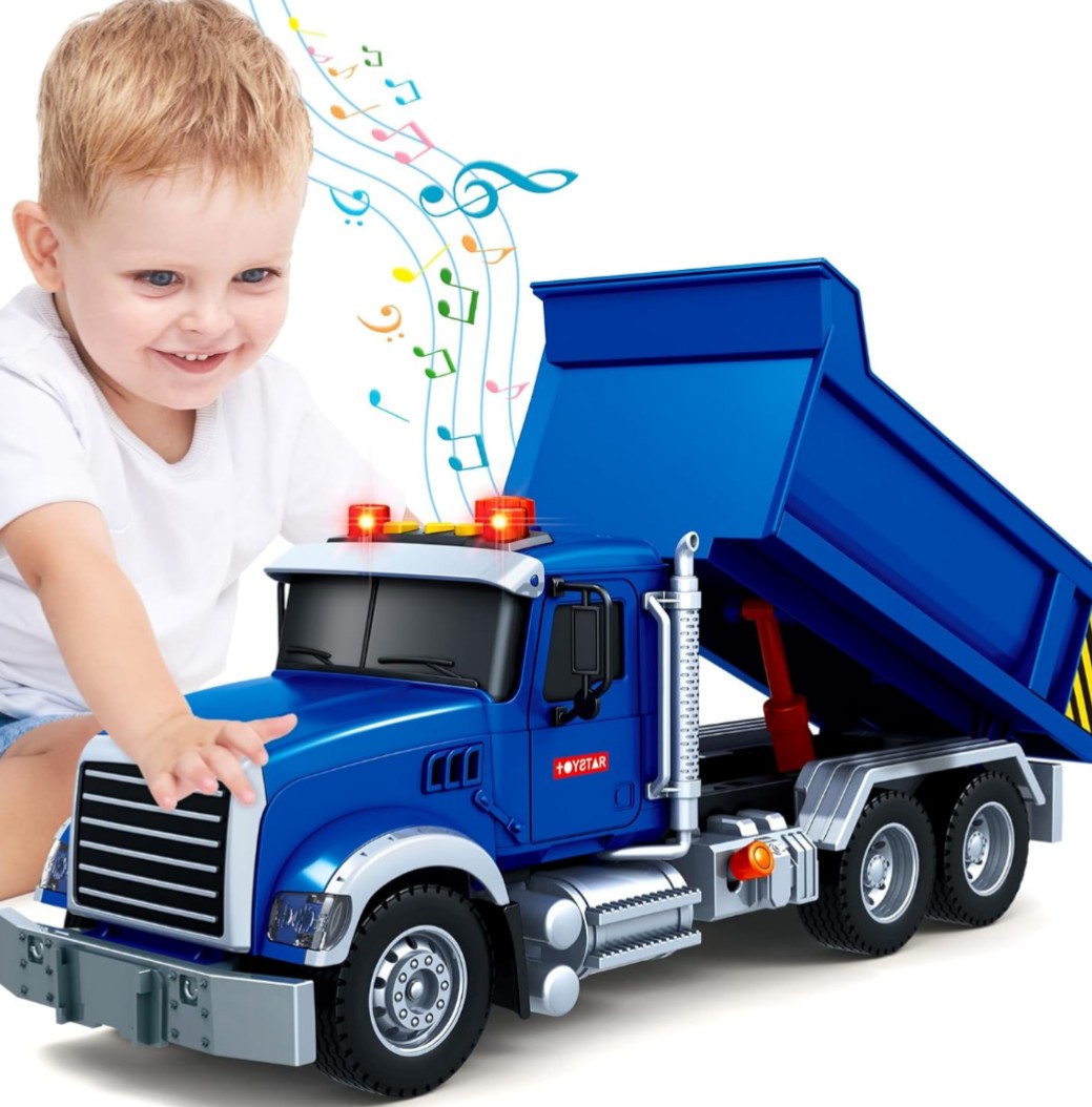 Smiling child playing with a blue toy dump truck on a white background