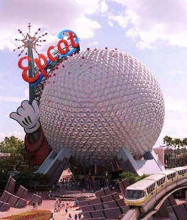 Large silver geodesic sphere dome structure with palm trees and pathways at base