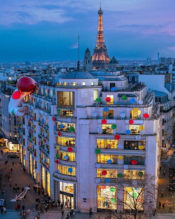 Illuminated Paris buildings at dusk with Eiffel Tower glowing in background