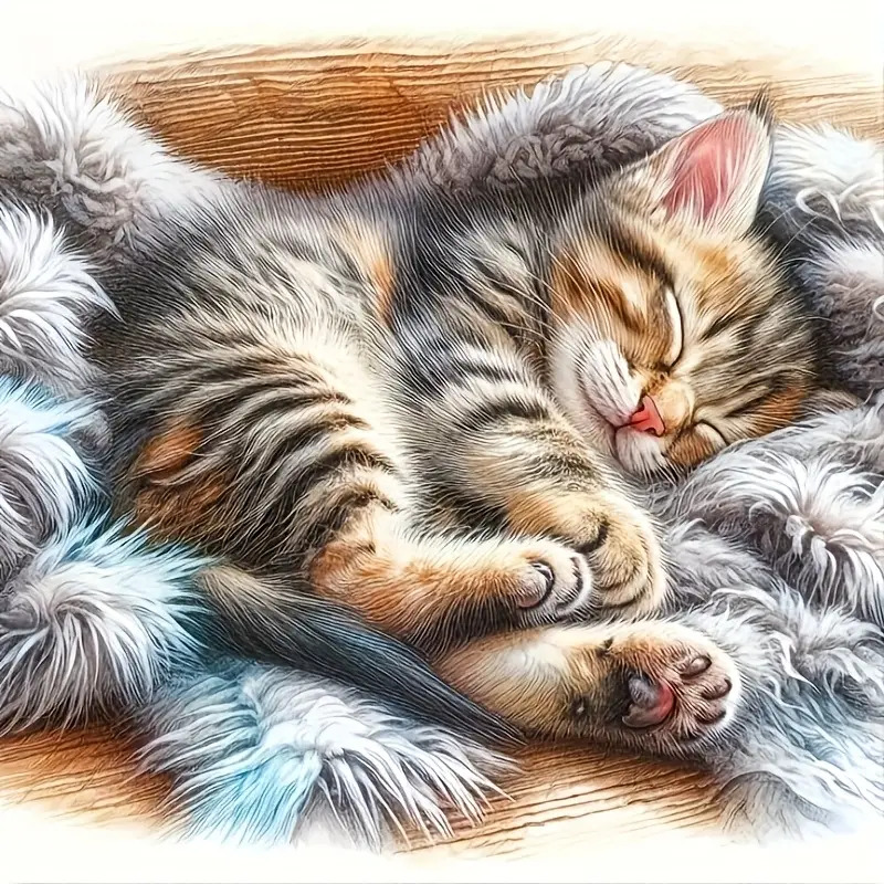 Striped tabby kitten sleeping peacefully on soft gray fur