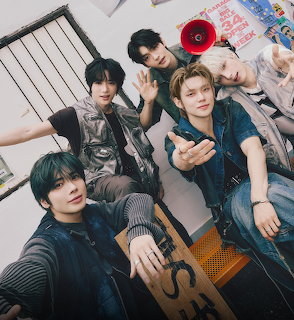 Five young men posing together indoors in a casual group portrait
