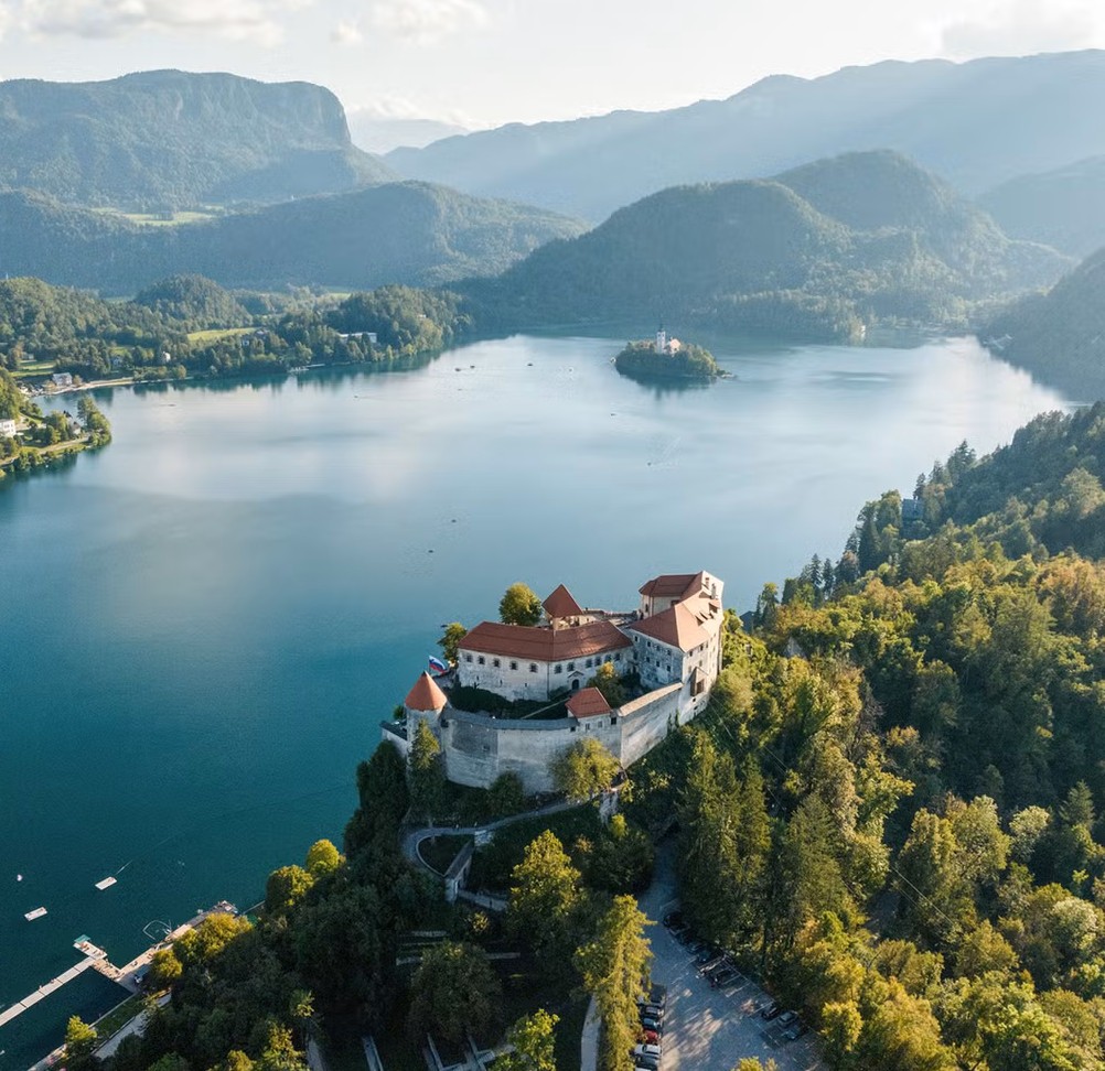 Hilltop castle above Lake Bled with forested hills and mountains in the background