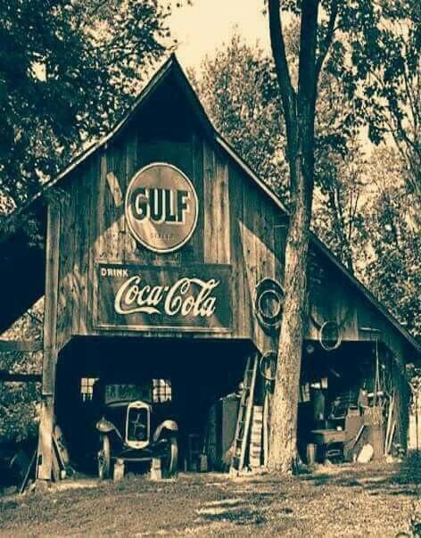 Rustic old barn with Gulf and Coca-Cola signs, vintage truck inside, sepia tone