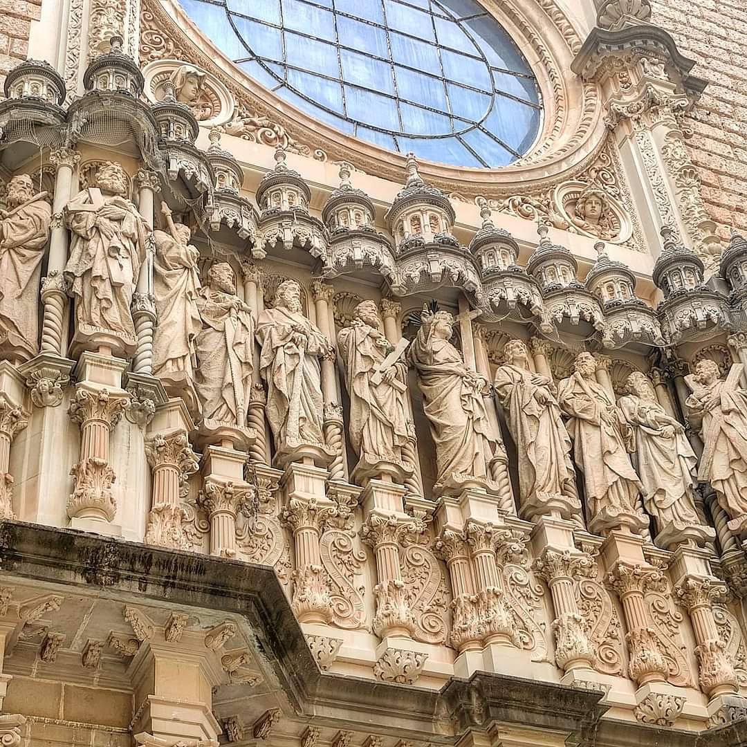 Detailed view of Montserrat monastery's sculptured facade with religious figures and rose window