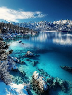 Snowy Lake Tahoe shoreline with turquoise water and mountain reflections