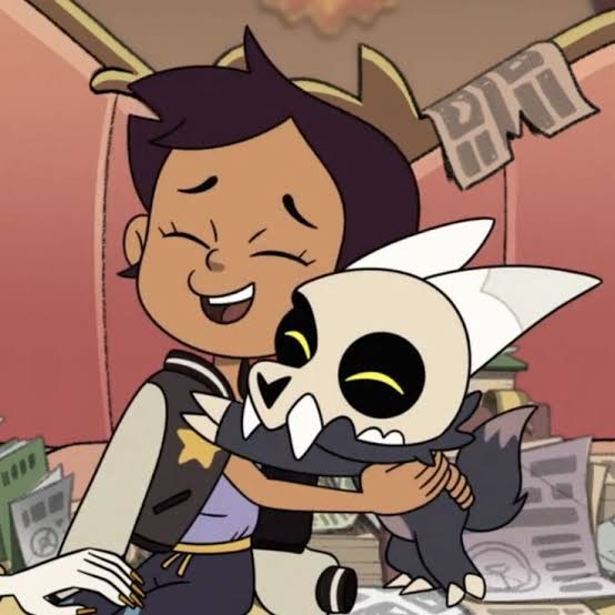 Cartoon girl hugging a small horned creature while smiling indoors