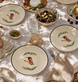Sunlit dining table with Zsolnay porcelain plates decorated with bird illustrations