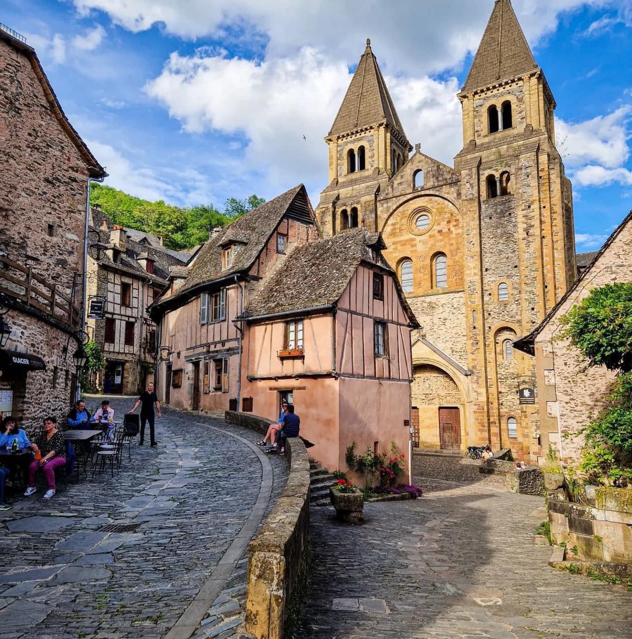 Medieval French village with twin-towered abbey and colorful historic houses along cobblestone street
