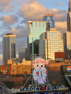 Downtown skyline at sunset behind Target Field with a Twins logo sign