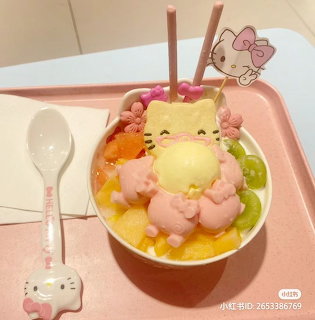 Shaved ice dessert with Hello Kitty decoration, pink dumplings, and fruit toppings in pink bowl