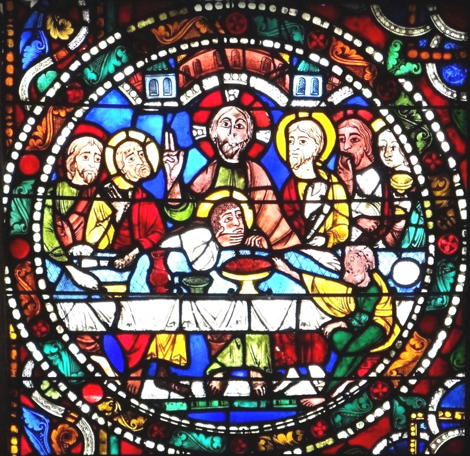 Circular stained glass window showing Last Supper scene with Jesus and disciples seated at table in medieval style