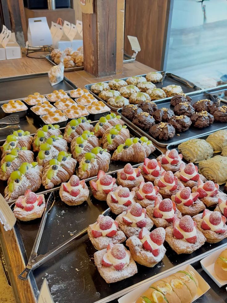 Croissants, strawberries and cake arranged on a cafe table
