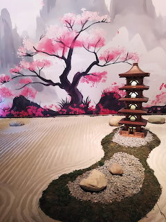 Stylized zen garden with raked sand, pink blossom tree, stones, and a small pagoda