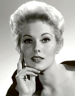 Black-and-white portrait of Kim Novak with short blonde hair and hand resting near her face