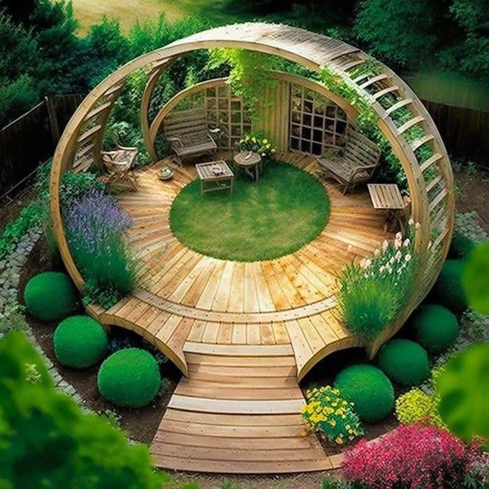Circular wooden garden pavilion with benches, grass center, and surrounding flowers