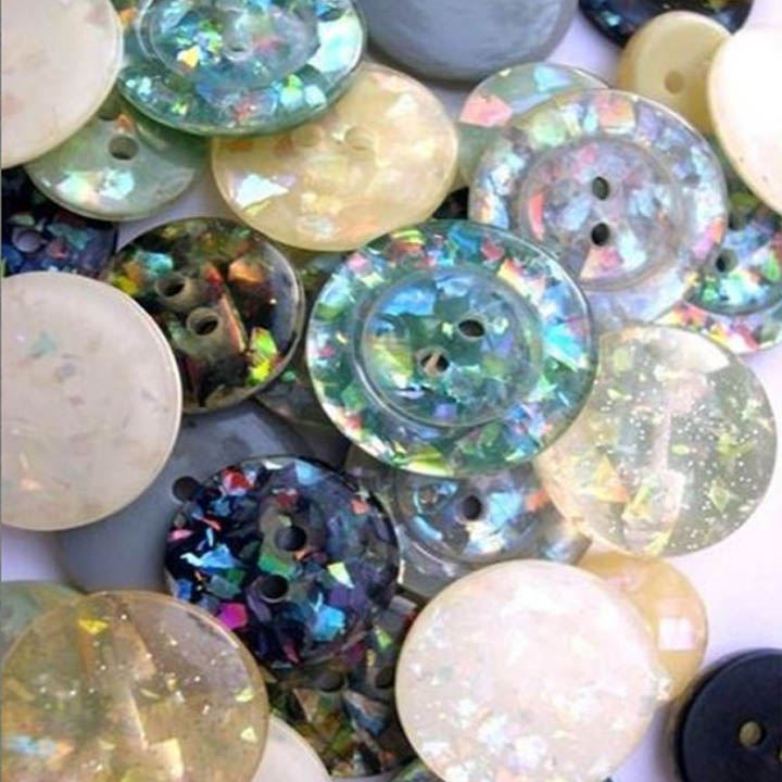 Close-up of assorted iridescent pastel buttons piled together
