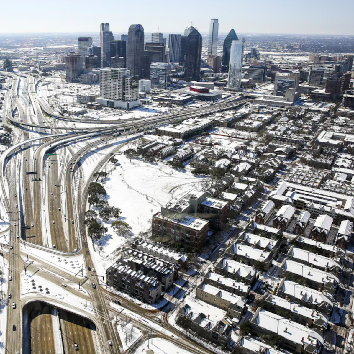 Aerial view of snow-covered Dallas skyline with highways and neighborhoods in winter