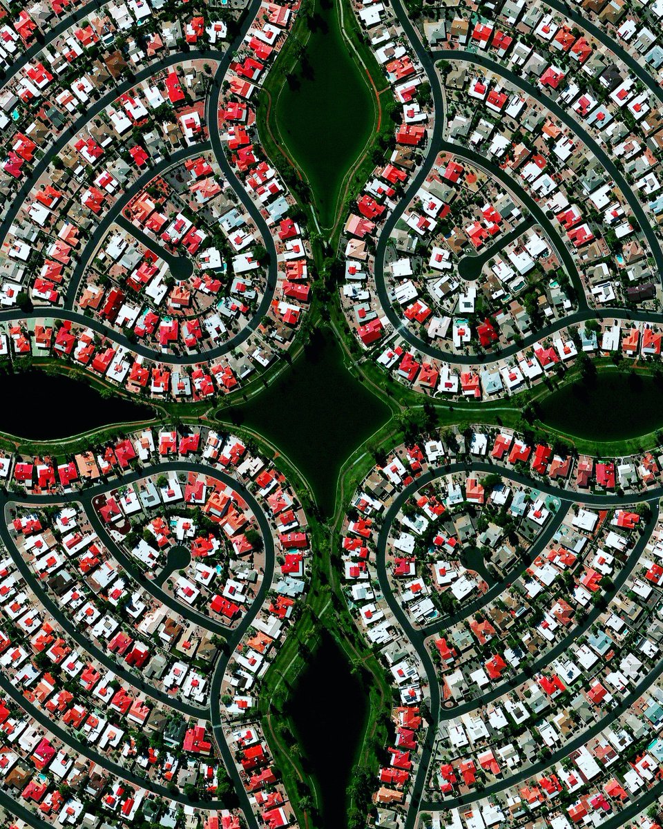 Aerial view of curved suburban streets with houses and green parks in Sun Lakes, Arizona