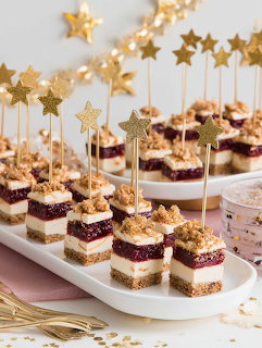 Layered cake squares on sticks with gold star toppers arranged on white platters