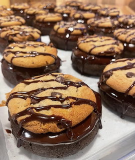 Chocolate-glazed brownie cookies topped with peanut butter cookies and chocolate drizzle on a white tray