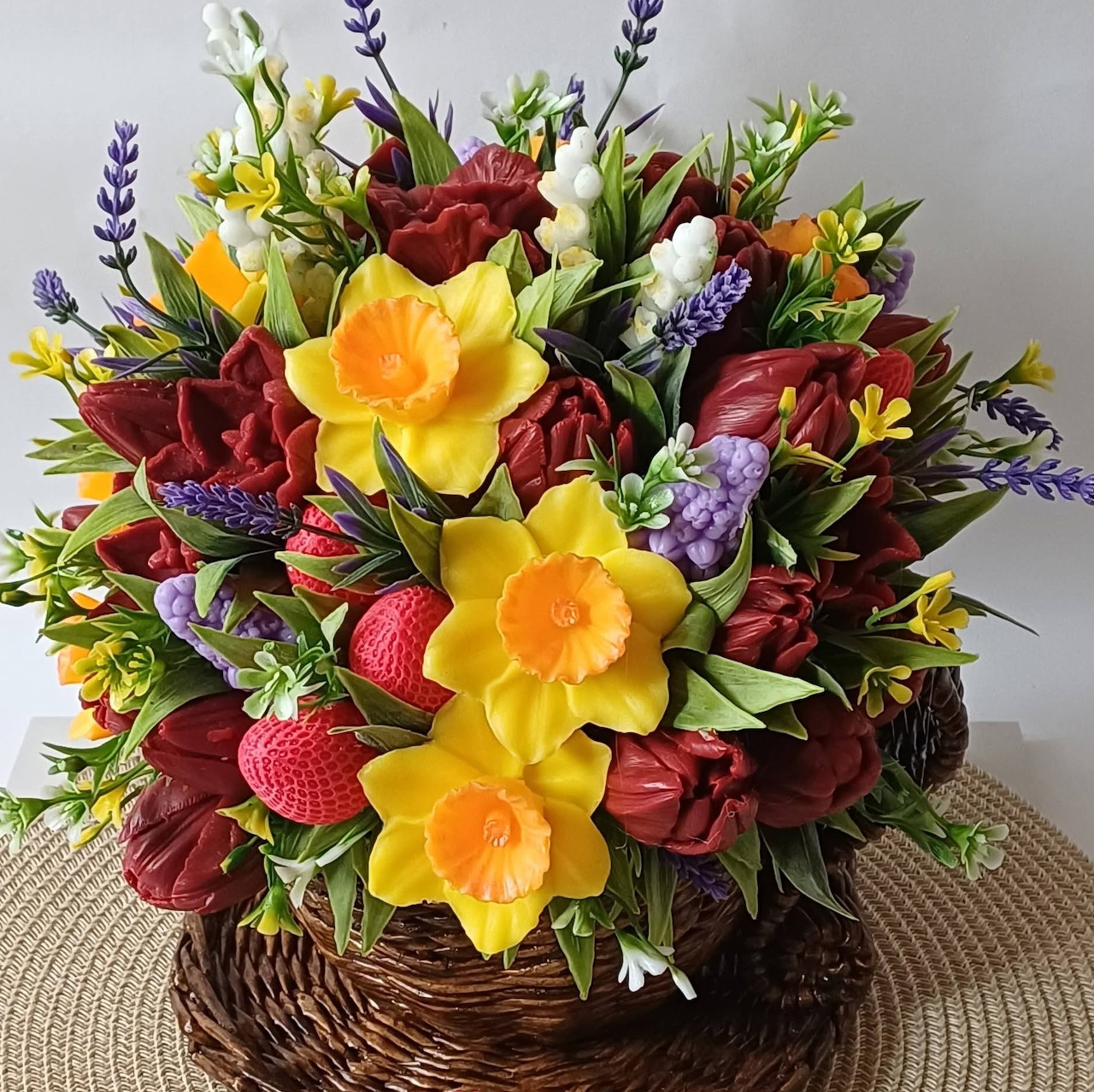 Vibrant spring flower basket with yellow daffodils, red roses, and purple lavender in woven wicker container
