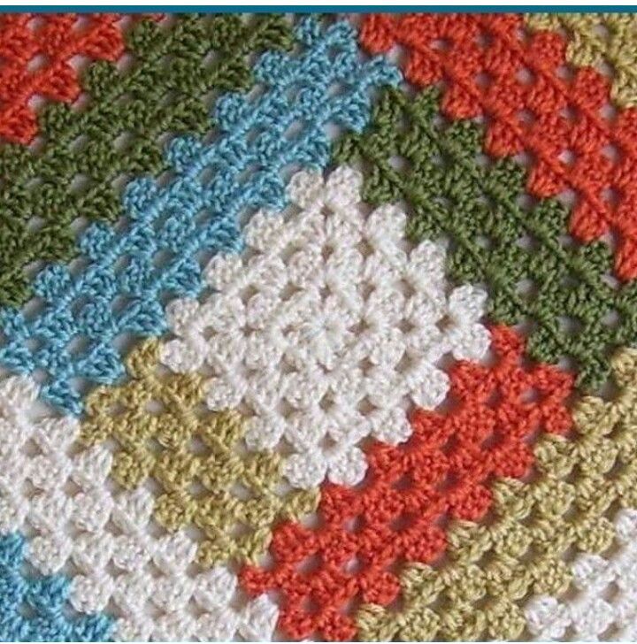 Colorful crochet granny squares with textured yarn in white, orange, green, and blue