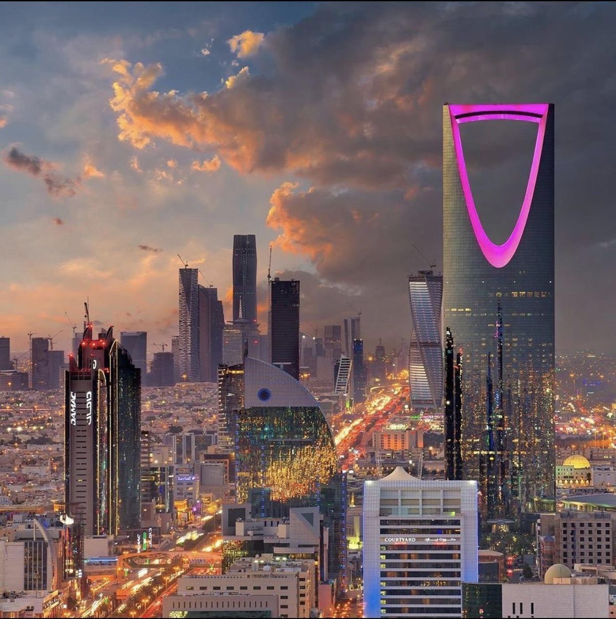 Riyadh skyline at sunset with illuminated skyscrapers and a glowing city street