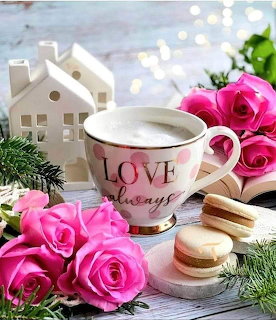 Teacup with LOVE text surrounded by pink roses, macarons, pine sprigs, and white house ornaments
