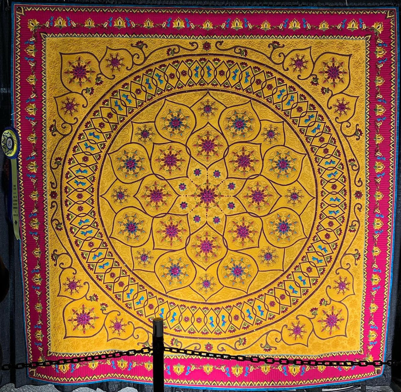 Yellow mandala tapestry with magenta border and intricate circular floral geometric patterns