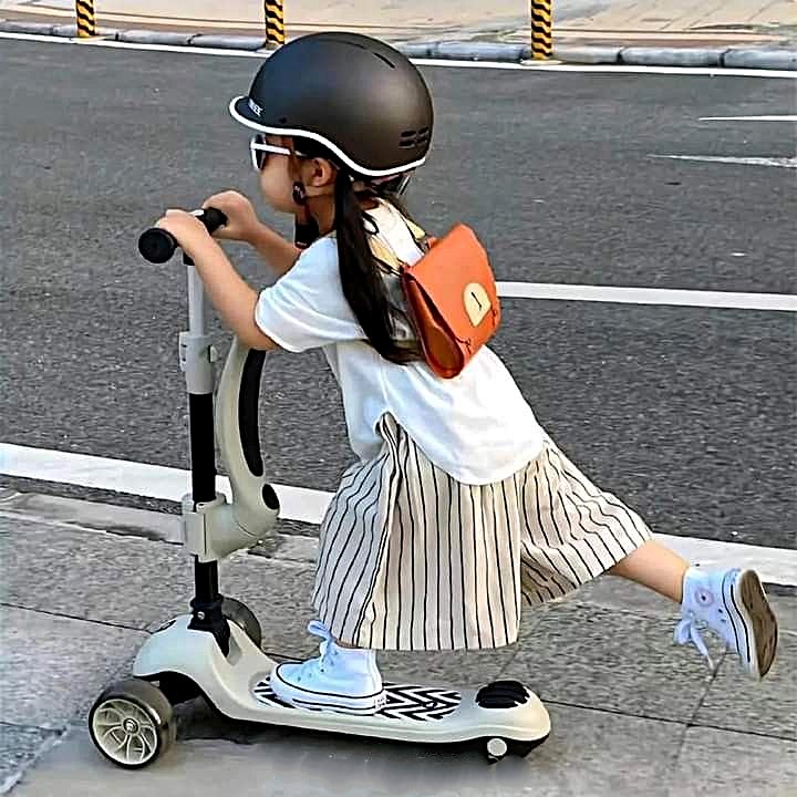 Young girl riding a scooter on a sidewalk with an orange backpack