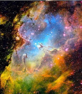 Colorful nebula in deep space with glowing blue, pink, yellow, and orange gas clouds and stars