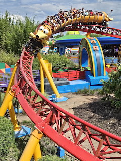 Slinky Dog themed roller coaster with yellow and red track at outdoor theme park