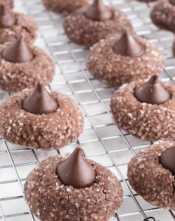 Chocolate blossom cookies topped with chocolate kisses on a wire cooling rack