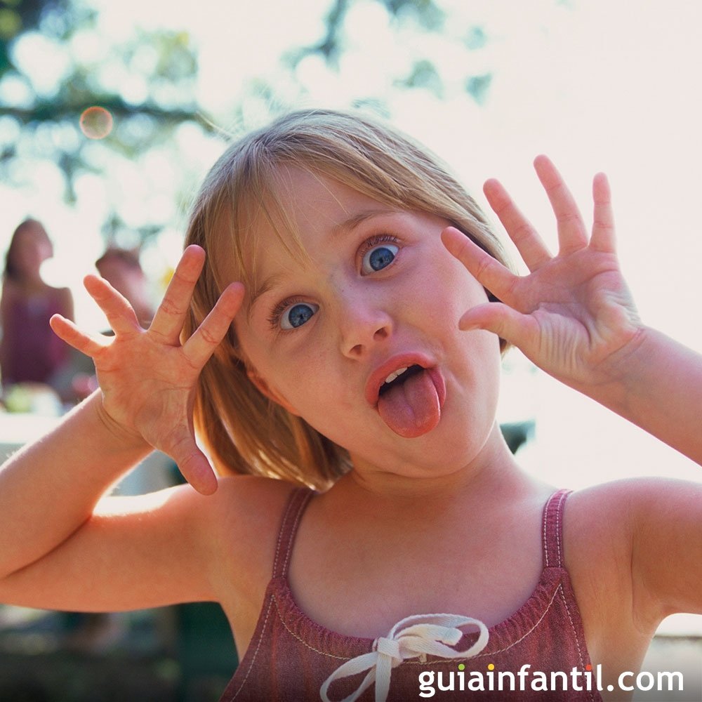 Young girl making a funny face with her tongue out and hands raised