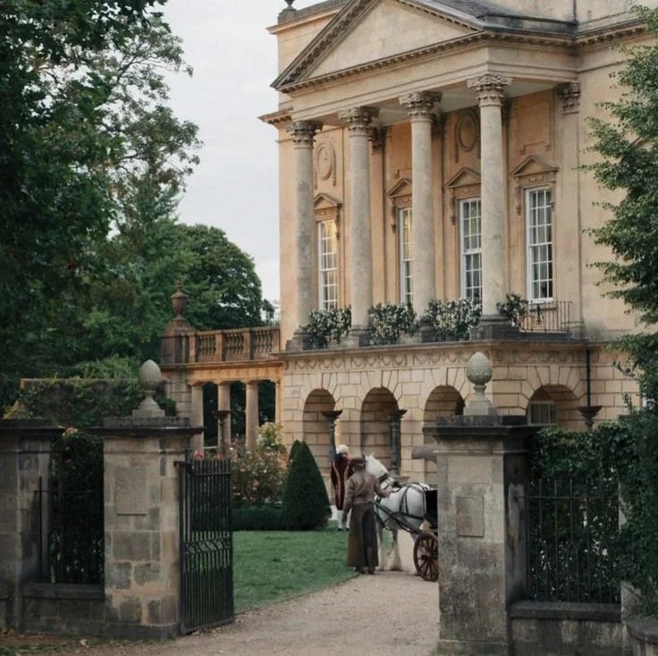Neoclassical mansion with columns and a horse-drawn carriage by the open gate