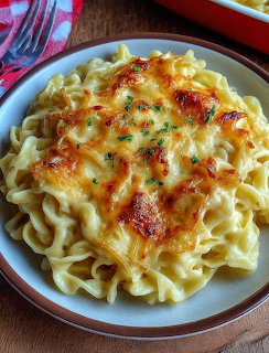 Baked pasta with melted cheese and herbs on white plate