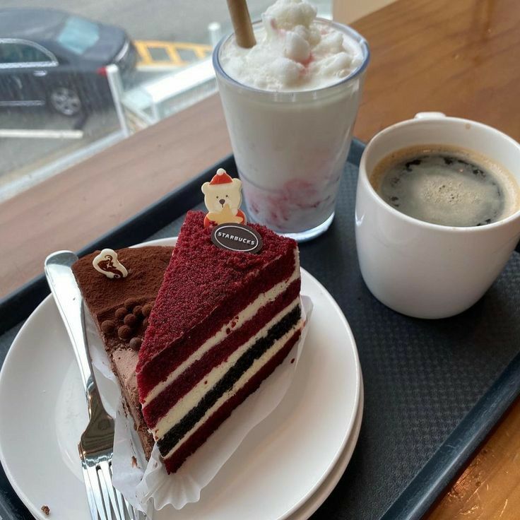 Red velvet cake slice with coffee and a strawberry milk drink on a tray