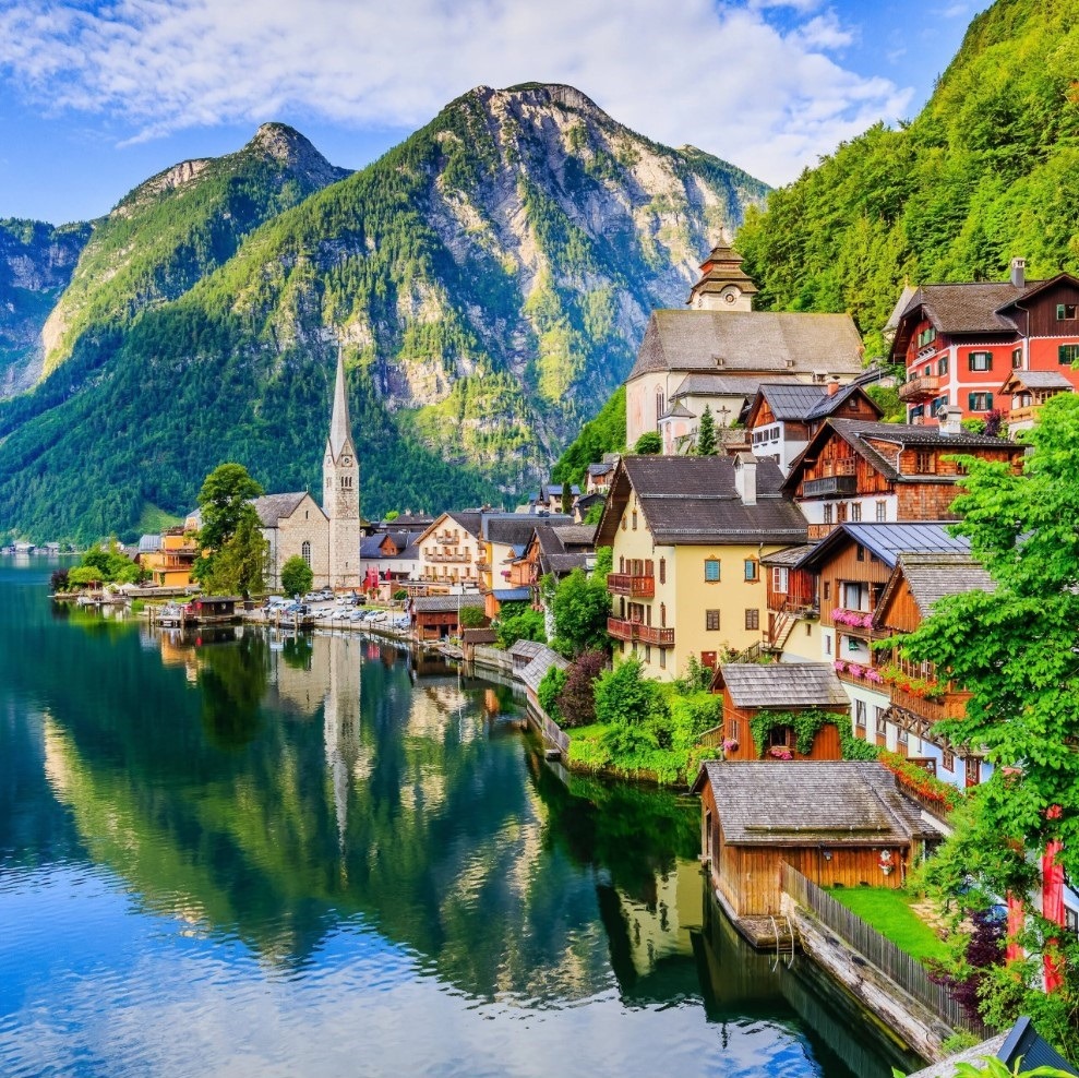 Lakeside village of Hallstatt, Austria, with colorful houses, church spire, mountains, and water reflections