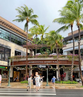 International Market Place entrance in Waikiki with palm trees and pedestrians on the street
