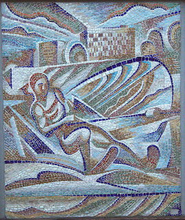 Byzantine-style mosaic showing angel with large wings in blue and white tiles with decorative wave border