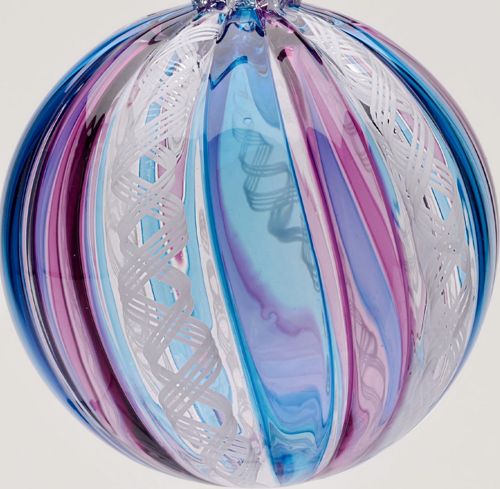 Round glass Christmas ornament with pink, blue, and white swirled stripes