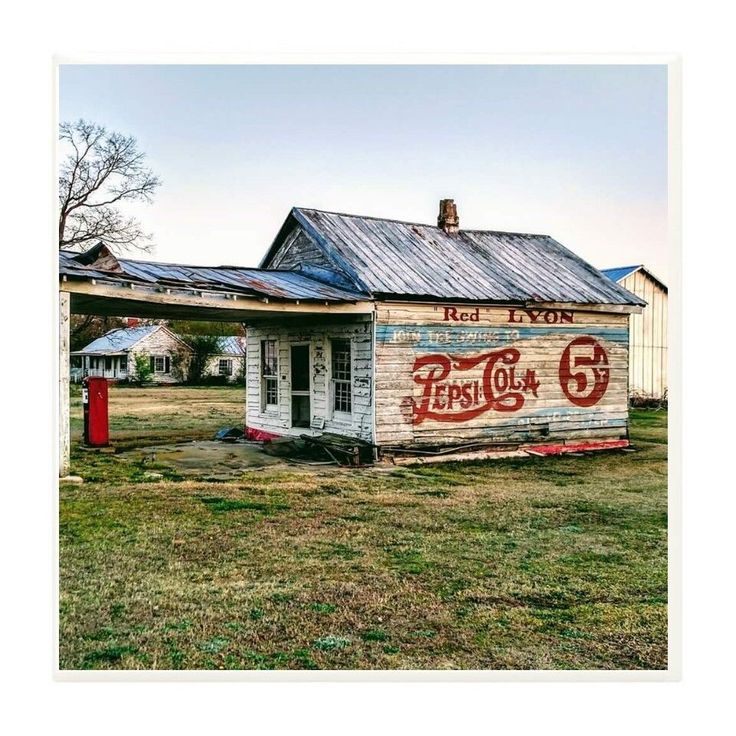 Weathered old service station building in a grassy rural lot