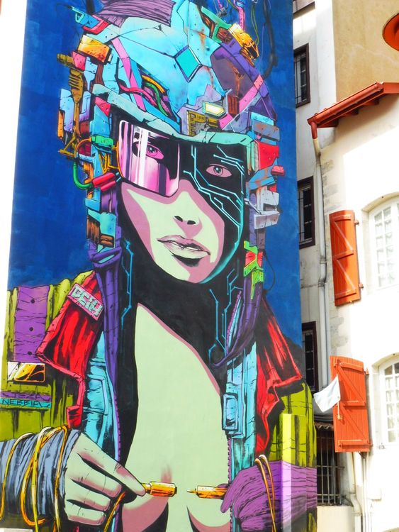 Colorful street art mural of a woman in large sunglasses on a building wall