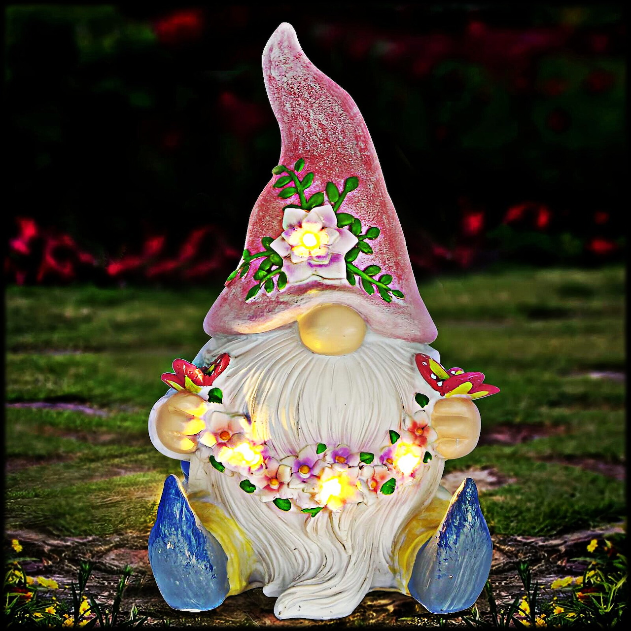 Garden gnome figurine with a pink hat, white beard, and flowers on mossy ground