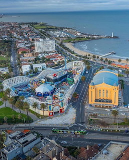 Aerial photograph of Luna Park Melbourne amusement park beside St Kilda beach and waterfront