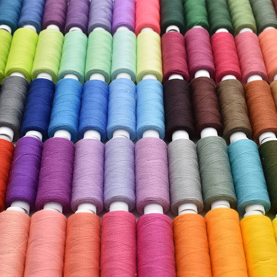 Rows of colorful thread spools arranged in a rainbow gradient pattern